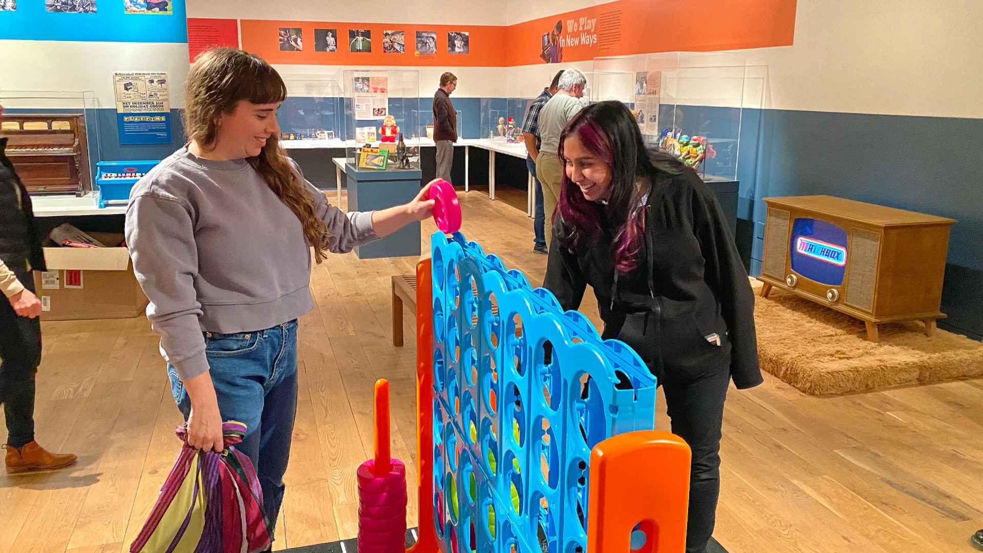 two women playing connect four in the exhibition