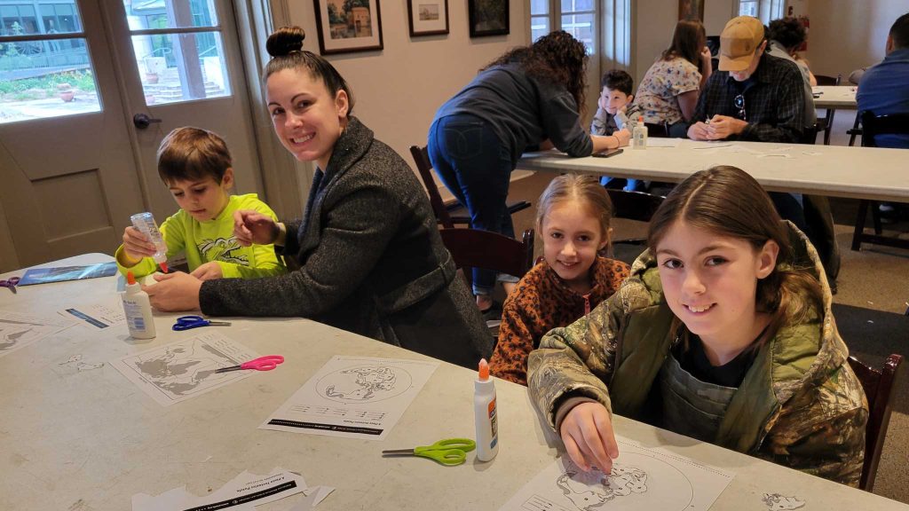 Mother and three children working on continents craft.