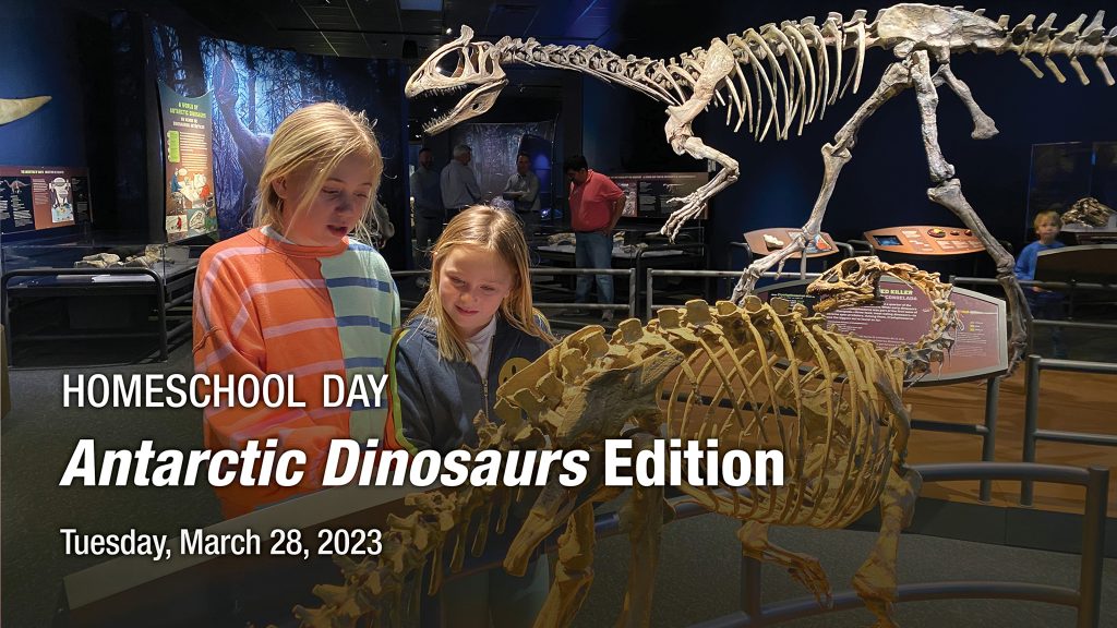 two girls looking curiously at a reconstructed small dinosaur fossil. Behind them stands the large cryolophosaurus fossil.