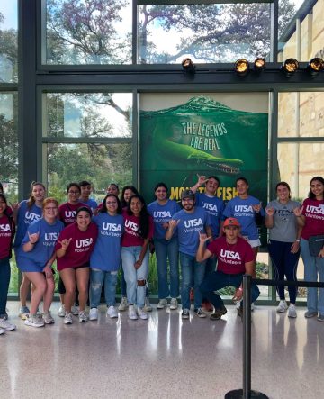 Students wearing UTSA volunteer t-shirts, standing in the HEB Lantern.