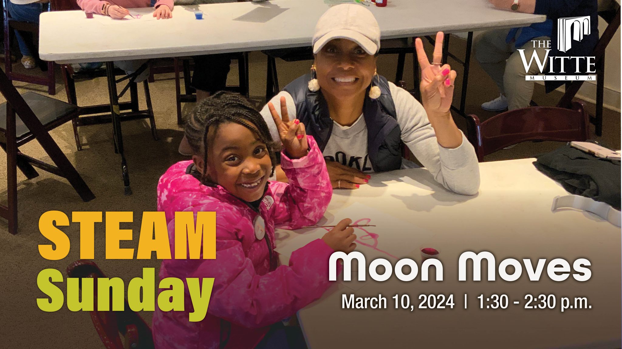 Mother and daughter make peace signs while sitting at science table.