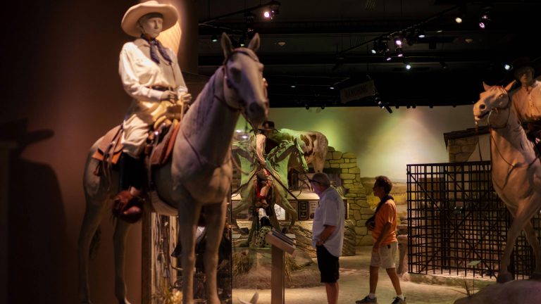 statue of woman on horse with onlookers behind